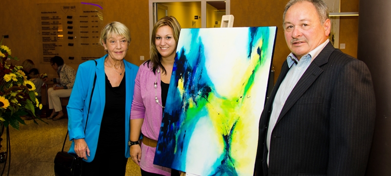 Künstlerin Bianca Lardi und Familie vor abstraktem Acrylbild bei Ausstellung