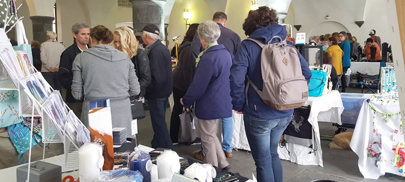 Besucher bei Kunstmarkt mit Werken der Künstlerin Bianca Lardi im Vordergrund