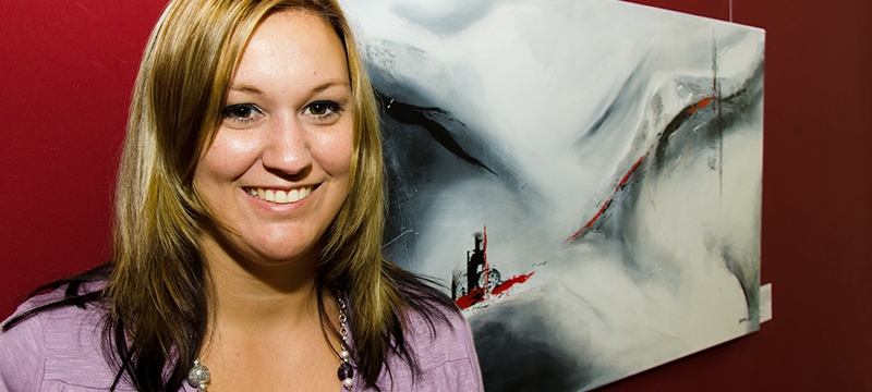 Künstlerin Bianca Lardi vor abstraktem Acrylbild bei Ausstellung