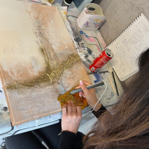 Eine Teilnehmerin des Workshops Struktur trifft Farbe 2.0 veredelt ihr Kunstwerk mit Goldfolie